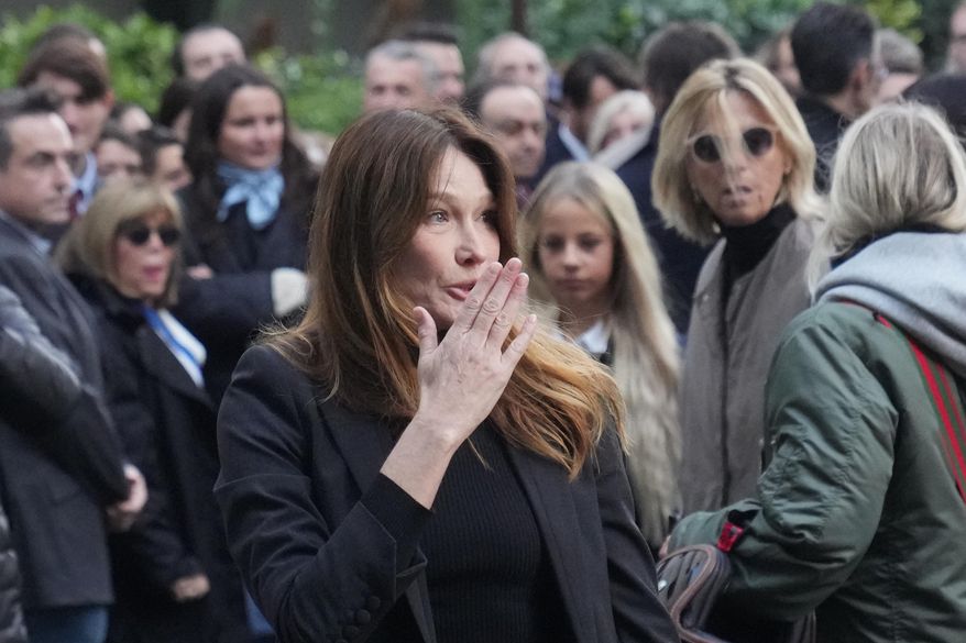 Carla Bruni-Sarkozy blows a kiss as her husband former French President Nicolas Sarkozy heads to prison to serve time for a criminal conspiracy to finance his 2007 election campaign with funds from Libya. Tuesday, Oct. 21, 2025 in Paris. (AP Photo/Thibault Camus)