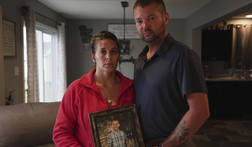 Ashlee and Erik Dahlberg hold a photo of their late son, Liam, in their home in Lowell, Ind., on Tuesday, Aug. 12, 2025. (AP Photo/Laura Bargfeld)