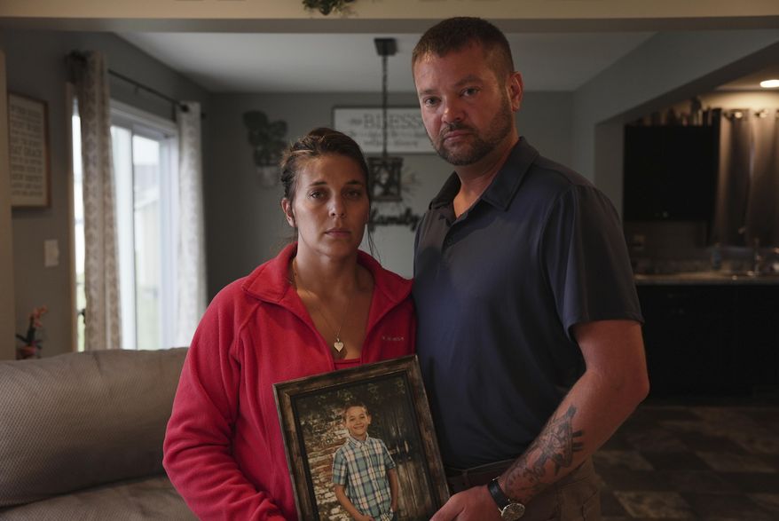 Ashlee and Erik Dahlberg hold a photo of their late son, Liam, in their home in Lowell, Ind., on Tuesday, Aug. 12, 2025. (AP Photo/Laura Bargfeld)