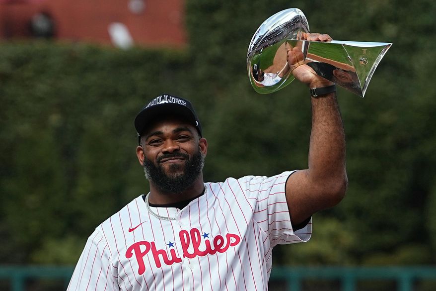 FILE - Former Philadelphia Eagles's Brandon Graham holds up the Vince Lombardi Trophy before throwing a ceremonial first pitch ahead of the Philadelphia Phillies' home-opener baseball game against the Colorado Rockies, March 31, 2025, in Philadelphia. (AP Photo/Matt Rourke, File)