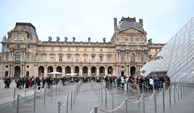 People queue outside the Louvre museum in Paris on Monday, Oct. 20, 2025, although it remains closed for the day after Sunday's jewels robbery. (AP Photo/Emma Da Silva)