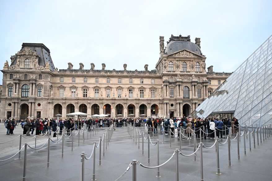 People queue outside the Louvre museum in Paris on Monday, Oct. 20, 2025, although it remains closed for the day after Sunday's jewels robbery. (AP Photo/Emma Da Silva)