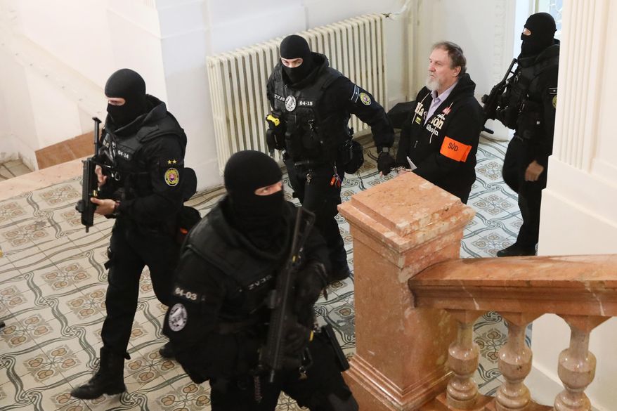 Juraj Cintula, who shot and seriously injured Prime minister of Slovakia Robert Fico last year, is convoyed at the Specialized Criminal Court in Banska Bystrica, Slovakia, Tuesday, Oct. 21, 2025. (Jan Kroslak/TASR via AP)