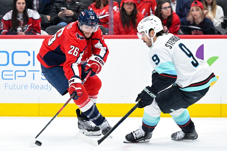 Washington Capitals center Nic Dowd (26) takes on Seattle Kraken center Chandler Stephenson (9) in the offensive zone during the third period at Capital One Arena, Washington, D.C., October 21, 2025. (Photo by Brian Murphy for the Washington Times)