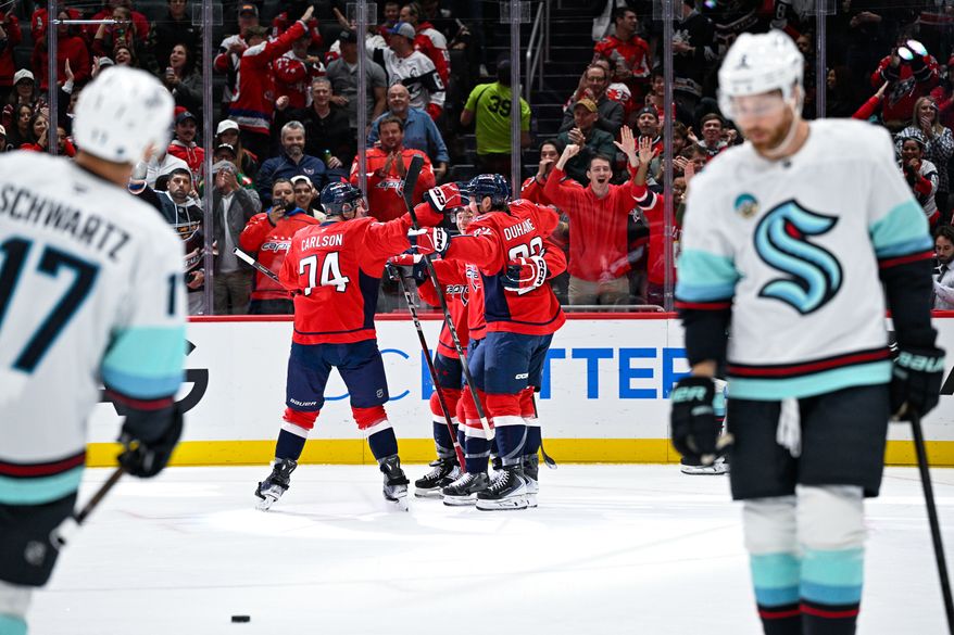Washington Capitals center Nic Dowd (26) celebrates with defenseman John Carlson (74) and others after scoring his first goal of the season against the Seattle Kraken at Capital One Arena, Washington, D.C., October 21, 2025. (Photo by Brian Murphy for the Washington Times)