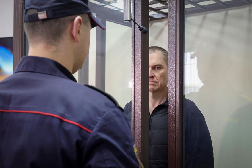 Journalist Andrzej Poczobut stands in a defendants' cage during a court session in Grodno, Belarus, Jan. 16, 2023. (Leonid Shcheglov/Pool via AP, File)