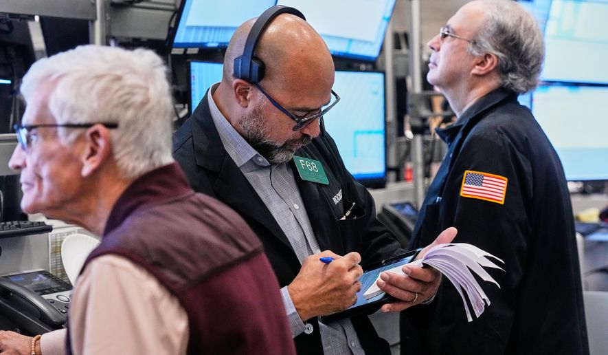 Options trader Steven Rodriguez, center, works on the floor of the New York Stock Exchange, Monday, Oct. 20, 2025. (AP Photo/Richard Drew)