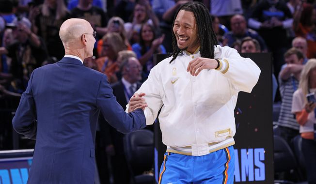 Oklahoma City Thunder forward Jaylin Williams, right, greets NBA commissioner Adam Silver during the championship ring ceremony before an NBA basketball game against the Houston Rockets, Tuesday, Oct. 21, 2025, in Oklahoma City. (AP Photo/Nate Billings)