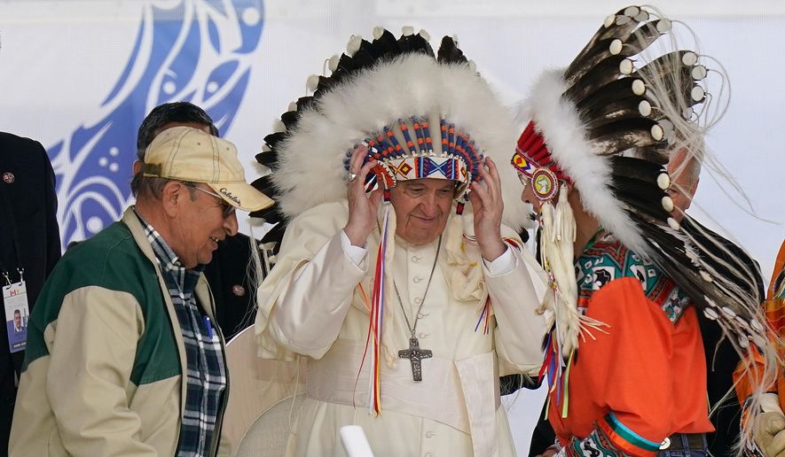 Pope Francis dons a headdress during a visit with Indigenous peoples at Maskwaci, the former Ermineskin Residential School, Monday, July 25, 2022, in Maskwacis, Alberta. (AP Photo/Eric Gay, File)