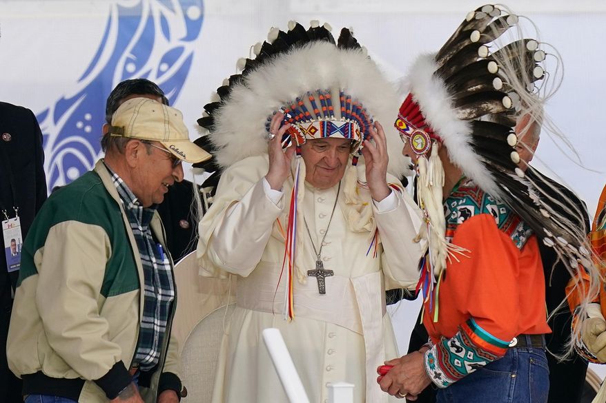 Pope Francis dons a headdress during a visit with Indigenous peoples at Maskwaci, the former Ermineskin Residential School, Monday, July 25, 2022, in Maskwacis, Alberta. (AP Photo/Eric Gay, File)