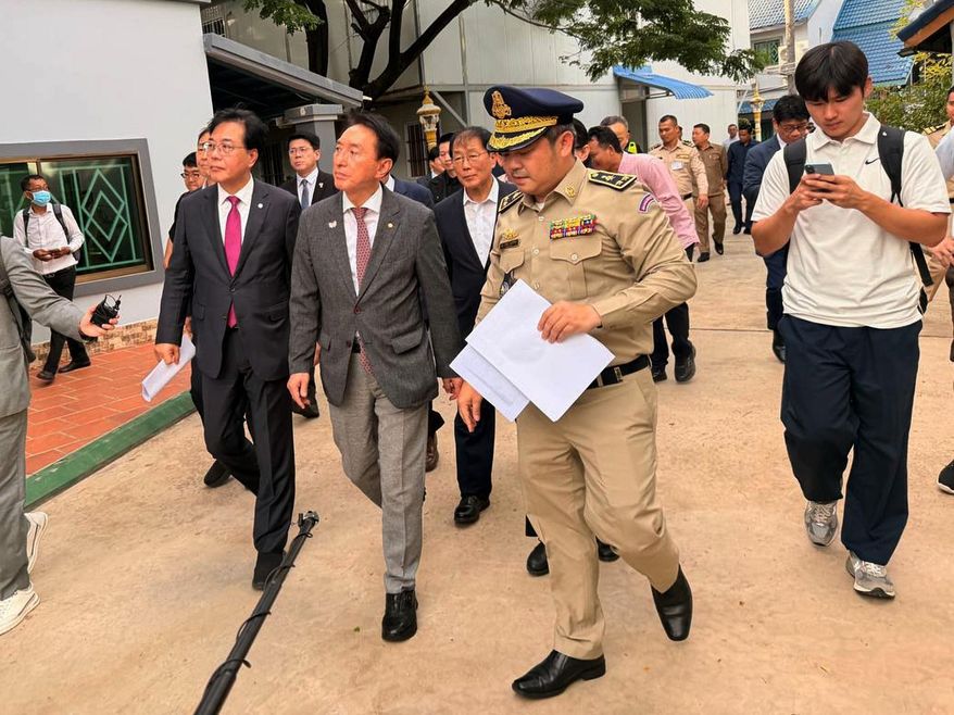 In this photo released by Secretariat of the Commission for Combating Online Scams (CCOS), a delegation of South Korean lawmakers, left, visit a building complex that was allegedly used for online scam work, outside Phnom Penh, Cambodia, Wednesday, Oct. 22, 2025. (CCOS via AP)