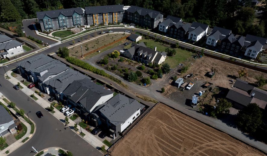 FILE - New construction homes and apartments are seen surrounding an older home on Friday, July 11, 2025, in Happy Valley, Ore. (AP Photo/Jenny Kane, File)