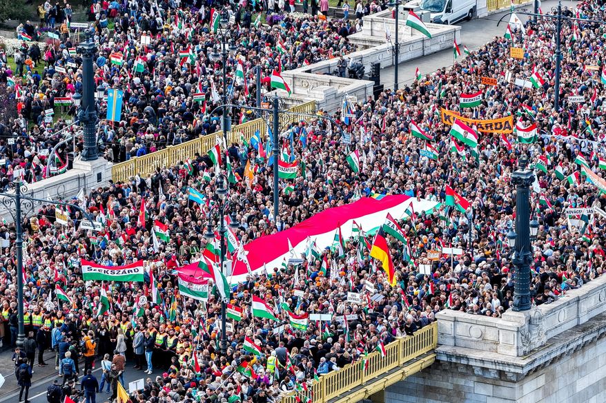 In this photo taken by a drone, participants of the Peace March organized by the pro-government Civil Unity Forum (COF) and its foundation Civil Unity Public Benefit Foundation (COKA) gather at the Buda side of Margaret Bridge in Budapest, Hungary, Thursday, Oct. 23, 2025, on the 69th anniversary of the Hungarian revolution and war of independence against communist rule and the Soviet Union in 1956. (Zsolt Czegledi/MTI via AP)
