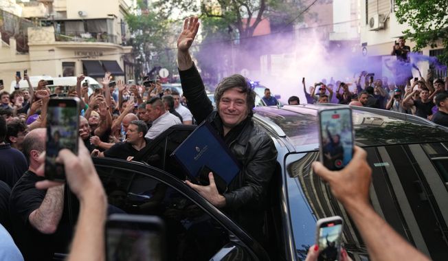 Argentine President Javier Milei waves to supporters upon arriving at a hotel in Rosario, Argentina, Thursday, Oct. 23, 2025. (AP Photo/Rodrigo Abd)