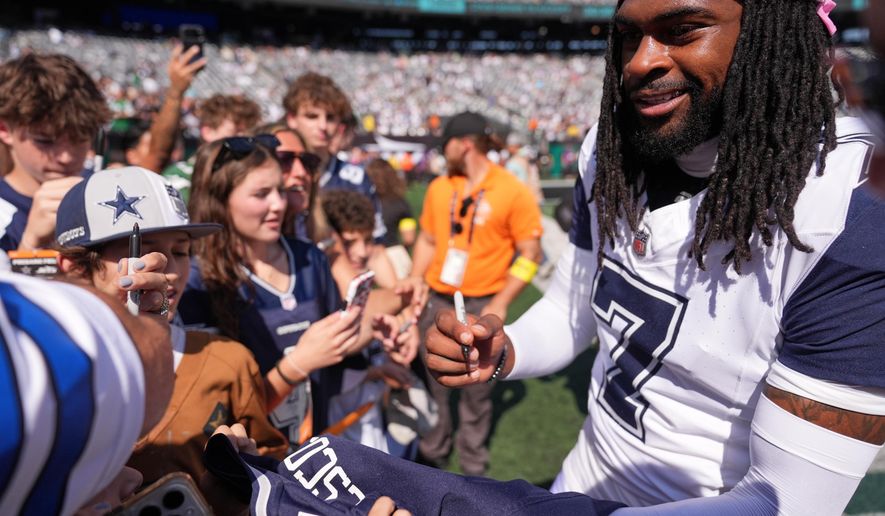 Dallas Cowboys' Trevon Diggs signs autographs before an NFL football game against the New York Jets Sunday, Oct. 5, 2025, in East Rutherford, N.J. (AP Photo/Seth Wenig)