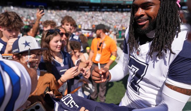 Dallas Cowboys' Trevon Diggs signs autographs before an NFL football game against the New York Jets Sunday, Oct. 5, 2025, in East Rutherford, N.J. (AP Photo/Seth Wenig)