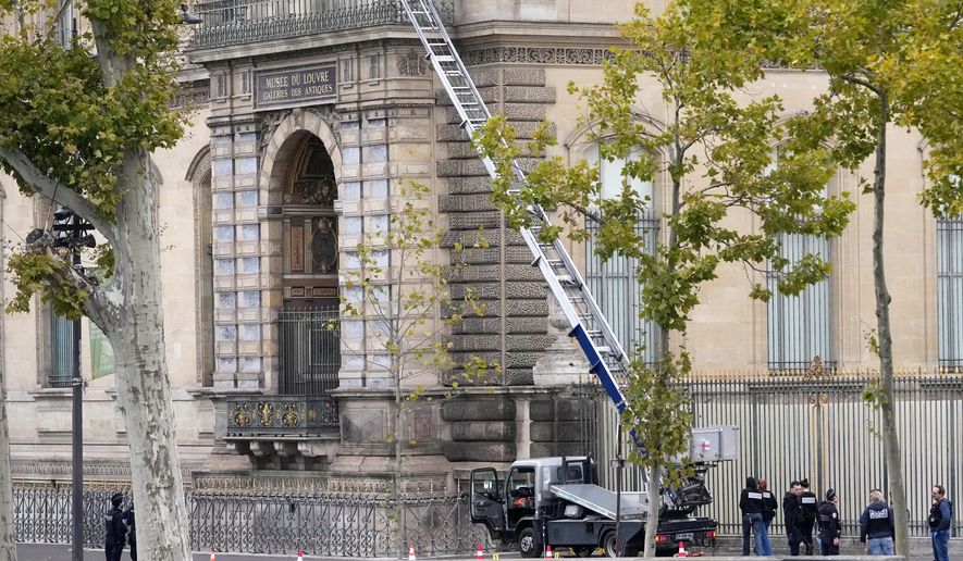 Police officers work by a basket lift used by thieves Sunday, Oct. 19, 2025 at the Louvre museum in Paris. (AP Photo/Thibault Camus)