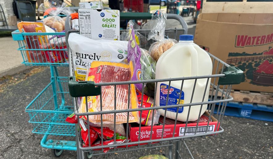 Food and milk sit in a shopping cart during a Forgotten Harvest distribution event held at Woodside Bible Church, Friday, Oct. 24, 2025, in Pontiac, Mich. (AP Photo/Mike Householder) ** FILE **