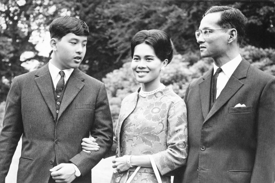 FILE - King Bhumibol of Thailand, right, walks with his wife Queen Sirikit, center, and their 13-year-old son Crown Prince Vajiralongkorn through the gardens of their residence at Sunninghill, Berkshire, July 27, 1966, where they are staying during their private visit to Britain. (AP Photo/Harris, File)