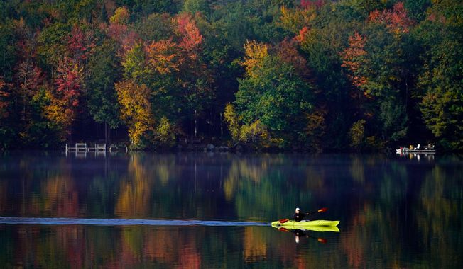 Virginia Davidson of Bridgton, Maine, paddles her kayak on Moose Pond, Oct. 13, 2021, in Bridgton, Maine. (AP Photo/Robert F. Bukaty)