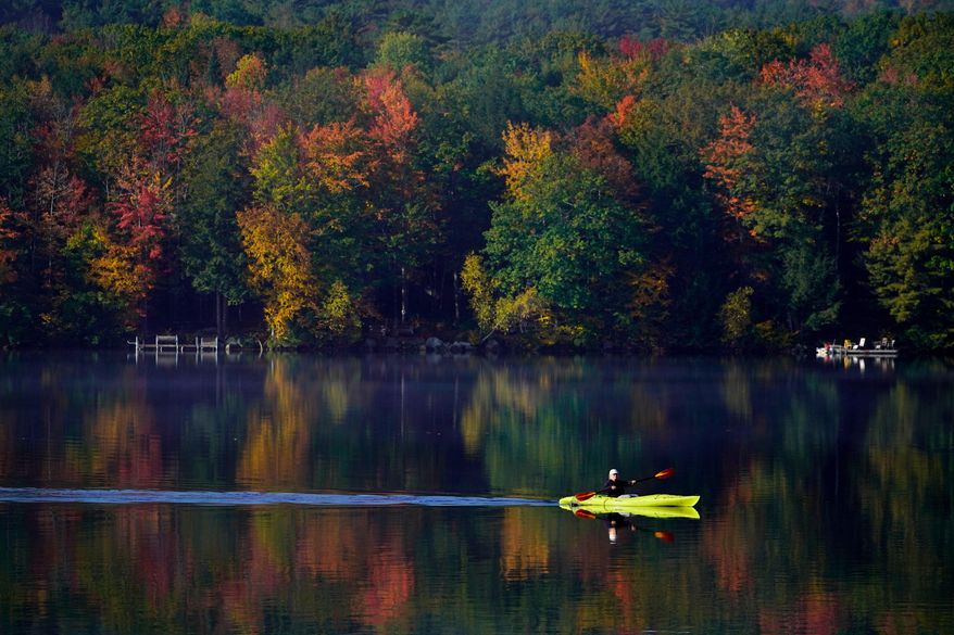 Virginia Davidson of Bridgton, Maine, paddles her kayak on Moose Pond, Oct. 13, 2021, in Bridgton, Maine. (AP Photo/Robert F. Bukaty)