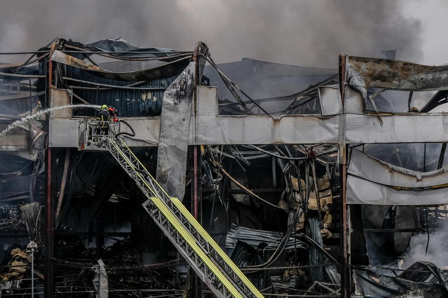 A firefighter works to extinguish a fire at a warehouse following a Russian attack, Saturday, Oct. 25, 2025, in Kyiv, Ukraine. (AP Photo/Julia Demaree Nikhinson)