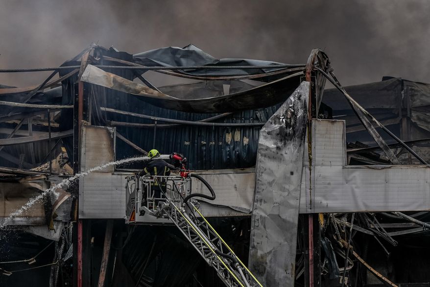 A firefighter works to extinguish a fire at a warehouse following a Russian attack, Saturday, Oct. 25, 2025, in Kyiv, Ukraine. (AP Photo/Julia Demaree Nikhinson)