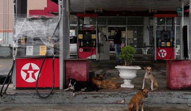 Fuel pumps are covered in plastic at a gas station ahead of the arrival of Hurricane Melissa in Kingston, Jamaica, Sunday, Oct. 26, 2025. (AP Photo/Matias Delacroix)