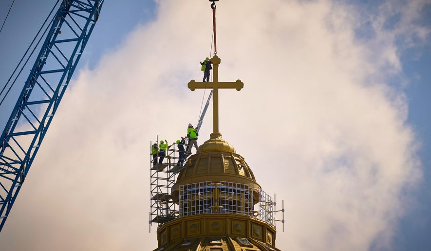 A construction worker gives a thumbs up in the final stages of installation for the main cross of the National Cathedral, in Bucharest, Romania, Tuesday, April 8, 2025. (AP Photo/Vadim Ghirda, File)