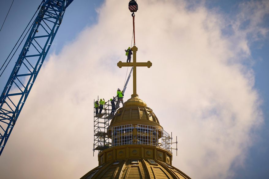 A construction worker gives a thumbs up in the final stages of installation for the main cross of the National Cathedral, in Bucharest, Romania, Tuesday, April 8, 2025. (AP Photo/Vadim Ghirda, File)
