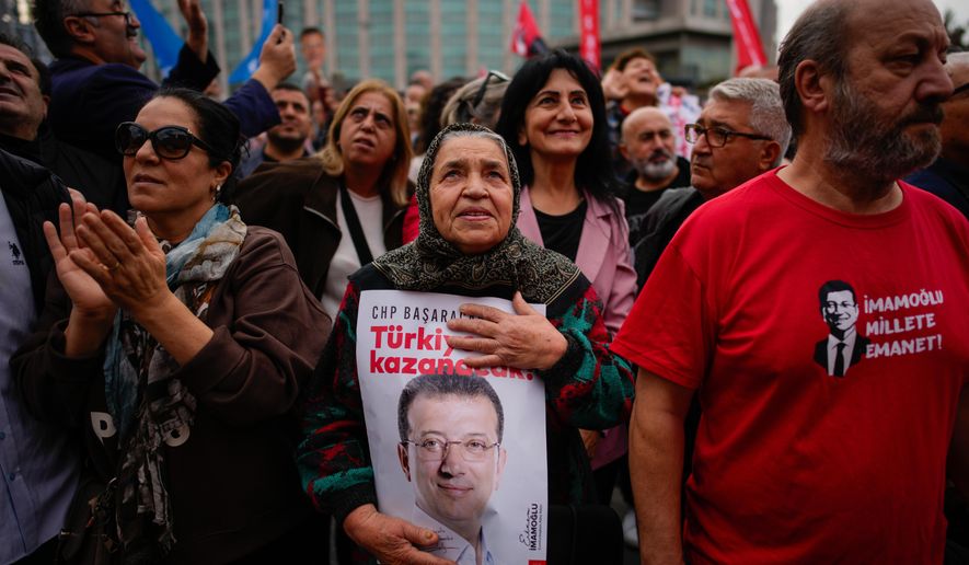 People listen to speeches during a rally in support of Istanbul's imprisoned opposition Mayor Ekrem Imamoglu as he appears for a hearing at the Caglayan courthouse, in Istanbul, Turkey, Sunday, Oct. 26, 2025. The poster with the photo of Imamoglu reads in Turkish: "Turkey will win". (AP Photo/Emrah Gurel)
