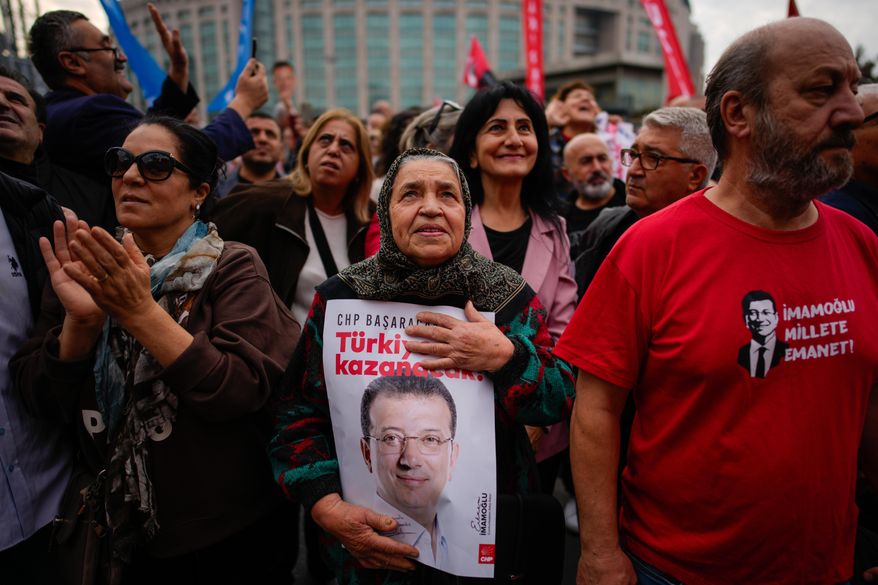 People listen to speeches during a rally in support of Istanbul's imprisoned opposition Mayor Ekrem Imamoglu as he appears for a hearing at the Caglayan courthouse, in Istanbul, Turkey, Sunday, Oct. 26, 2025. The poster with the photo of Imamoglu reads in Turkish: "Turkey will win". (AP Photo/Emrah Gurel)