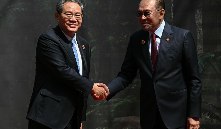 China's Premier Li Qiang, left, shakes hands with Malaysia's Prime Minister Anwar Ibrahim as he arrives at the Kuala Lumpur Convention Centre to attend the 47th Association of Southeast Asian Nations (ASEAN) summit in Kuala Lumpur, Malaysia, Monday, Oct. 27, 2025. (Lillian Suwanrumpha/Pool Photo via AP)