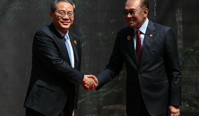 China's Premier Li Qiang, left, shakes hands with Malaysia's Prime Minister Anwar Ibrahim as he arrives at the Kuala Lumpur Convention Centre to attend the 47th Association of Southeast Asian Nations (ASEAN) summit in Kuala Lumpur, Malaysia, Monday, Oct. 27, 2025. (Lillian Suwanrumpha/Pool Photo via AP)