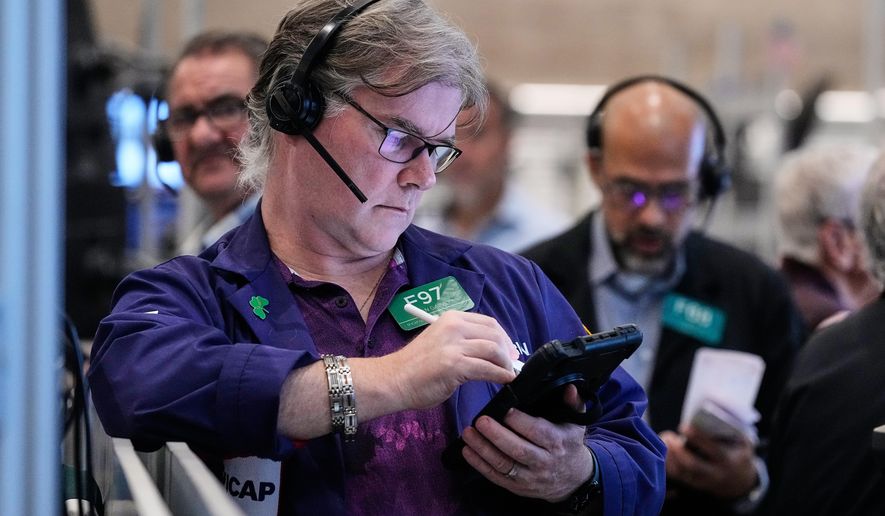 Options trader Brian Garvey, left, works on the floor of the New York Stock Exchange, Monday, Oct. 20, 2025. (AP Photo/Richard Drew)