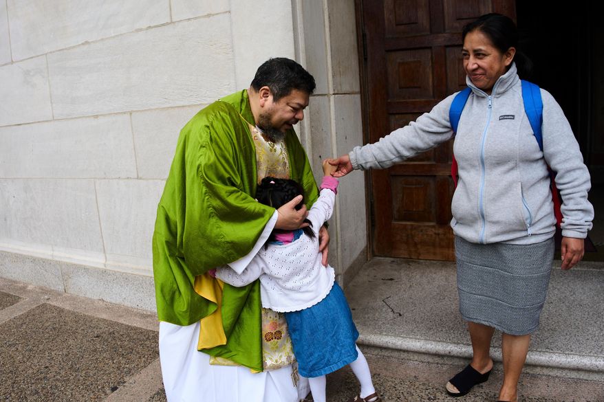 The Rev. Carlos Reyes greets parishioners after celebrating Mass at the Shrine of the Sacred Heart, a Catholic church in Washington, Sunday, Oct. 12, 2025. (AP Photo/Luis Andres Henao)