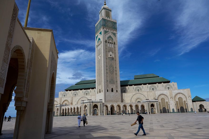 FILE - People walk past the great Hassan II Mosque in Casablanca, Morocco, Oct. 16, 2020. (AP Photo/Abdeljalil Bounhar, File)