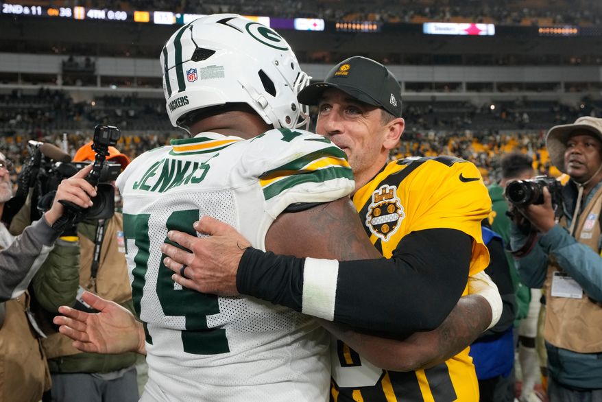 Pittsburgh Steelers' Aaron Rodgers hugs Green Bay Packers' Elgton Jenkins after an NFL football game Sunday, Oct. 26, 2025, in Pittsburgh. (AP Photo/Sue Ogrocki)