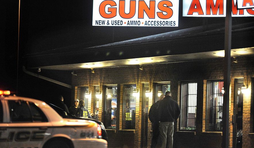 FILE - In this Dec. 20, 2012 file photo, law enforcement officials stand outside Riverview Gun Sales, as authorities raid the store in East Windsor, Conn. (AP Photo/Jessica Hill, File)