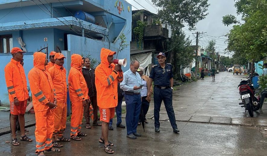 In this handout photo released by the National Disaster Response Force (NDRF), NDRF personnel warn residents of Cyclone Montha, in Yanam, in the Indian state of Andhra Pradesh, Monday, Oct. 27, 2025. (NDRF via AP)