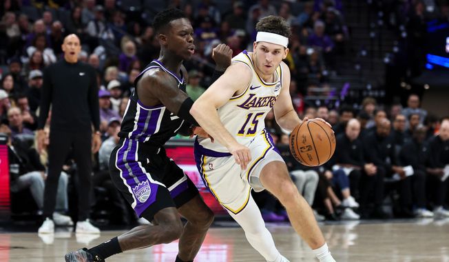 Los Angeles Lakers guard Austin Reaves (15) drives to the basket with Sacramento Kings guard Dennis Schröder, left, defending during the second half of an NBA basketball game Sunday, Oct. 26, 2025, in Sacramento, Calif. (AP Photo/Sara Nevis)