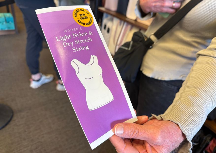 A woman holds a pamphlet for the new sleeveless sacred garments worn by members of The Church of Jesus Christ of Latter-day Saints at Deseret Book in Salt Lake City on Tuesday, Oct. 28, 2025. (AP Photo/Hannah Schoenbaum)