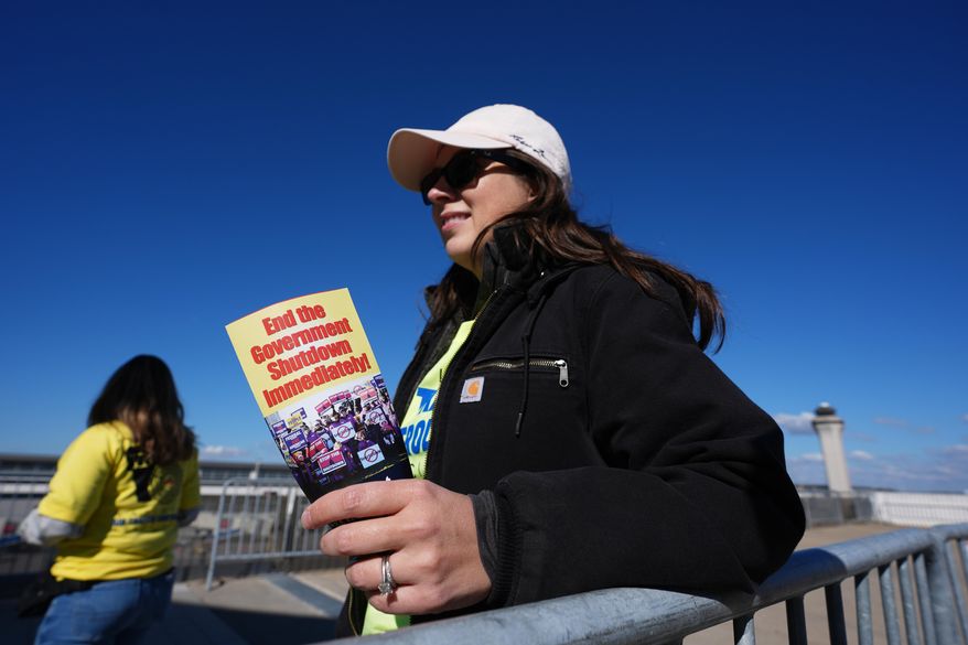 Air Traffic Controller Claudia Peterfeso distributes leaflets explaining how the federal government shutdown is impacting air travel at Detroit Metropolitan Wayne County Airport in Romulus, Mich., on Tuesday, Oct. 28, 2025. (AP Photo/Paul Sancya)