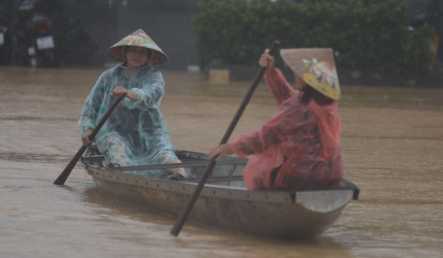 People paddle a boat on a flooded street in Hue, Vietnam, Tuesday, Oct. 28, 2025. (Van Dung/VNA via AP)