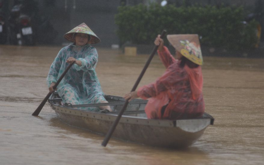 People paddle a boat on a flooded street in Hue, Vietnam, Tuesday, Oct. 28, 2025. (Van Dung/VNA via AP)