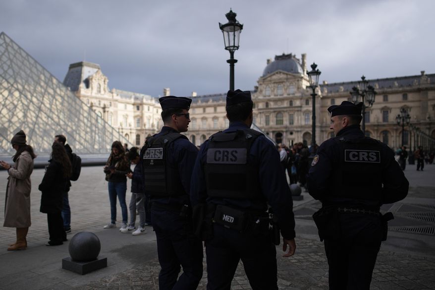 Riot police officers patrol as people queue to enter Le Louvre museum Monday, Oct. 27, 2025 in Paris. (AP Photo/Christophe Ena)