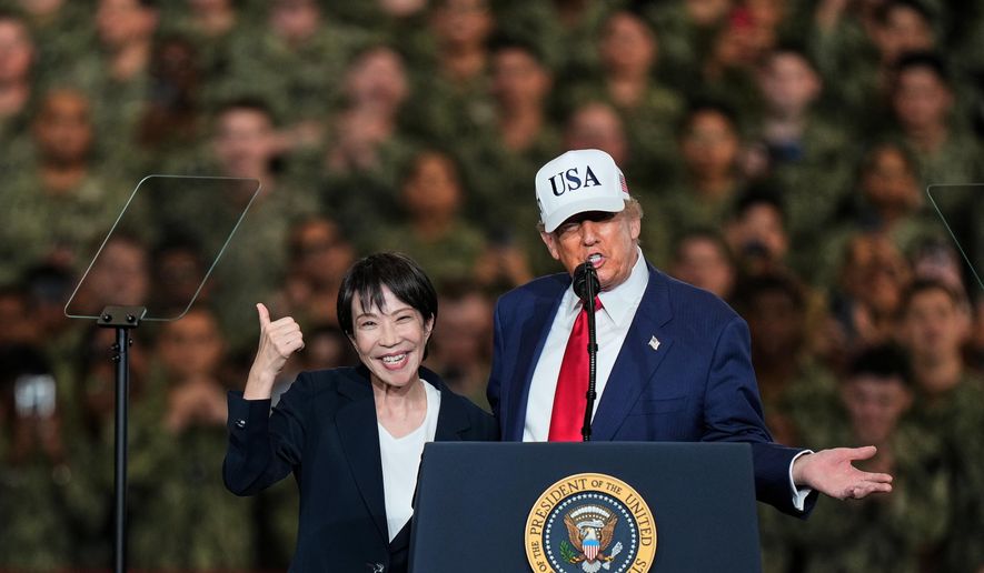 Japanese Prime Minister Sanae Takaichi gestures as U.S. President Donald Trump delivers his speech during their visit to the aircraft carrier USS George Washington at the U.S. Navy's Yokosuka base in Yokosuka, south of Tokyo, Tuesday, Oct. 28, 2025. (AP Photo/Eugene Hoshiko)
