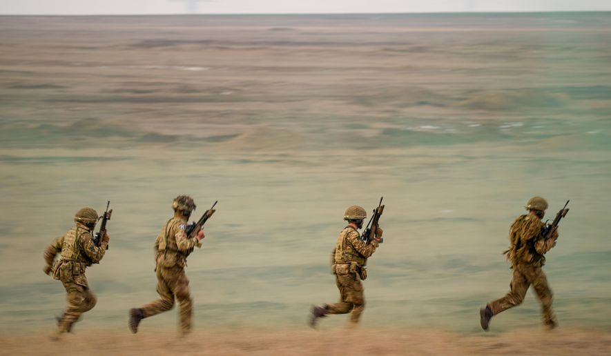 Servicemen run during the Steadfast Dart 2025 exercise, involving some 10,000 troops in three different countries from nine nations, representing the largest NATO operation planned this year, at a training range in Smardan, eastern Romania, Wednesday, Feb. 19, 2025. (AP Photo/Vadim Ghirda, file)