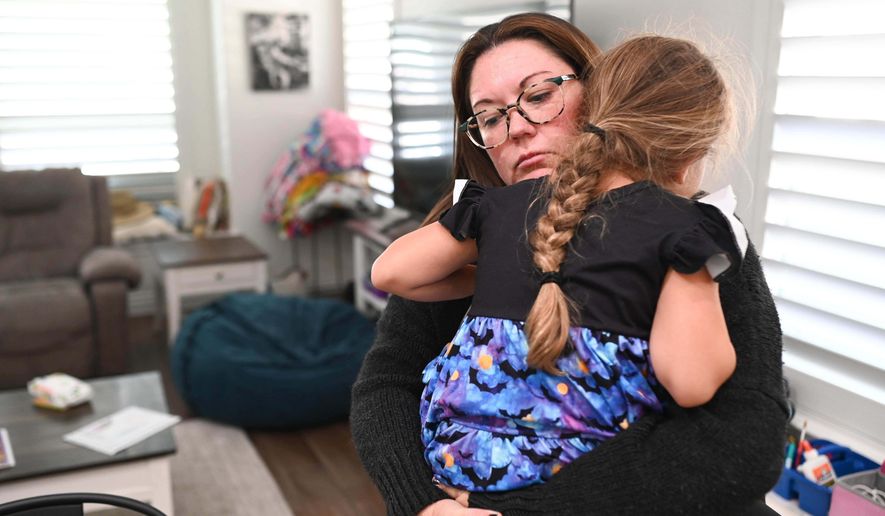 Jennifer Bittner holds her 6-year-old daughter Amelia at their home on Wednesday, Oct. 29, 2025, in Pflugerville, Texas. (AP Photo/Jack Myer)