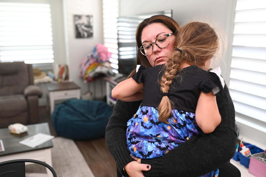 Jennifer Bittner holds her 6-year-old daughter Amelia at their home on Wednesday, Oct. 29, 2025, in Pflugerville, Texas. (AP Photo/Jack Myer)